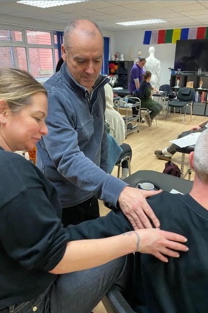 Lee and students practising a hands-on technique during clinic training